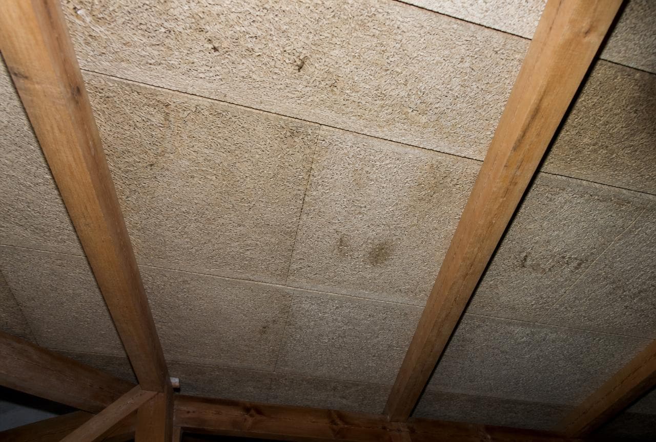 Dachstockdecke mit hellen Holzwolle-Leichtbauplatten zwischen Holzbalken