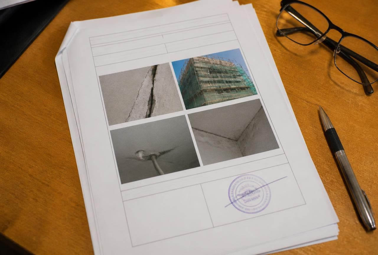 Gedruckter Prüfbericht mit Fotodokumentation und Stempel auf einem Schreibtisch