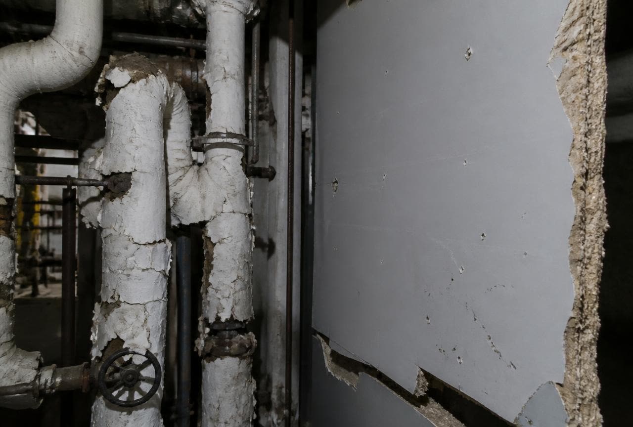 Alte Heizungsleitungen mit bröckelnder weisser Isolation und beschädigte Leichtbauplatte im Kellerraum